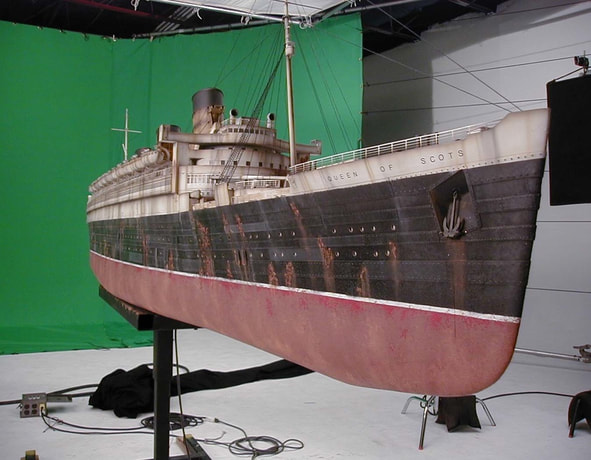Scale model of the ship Queen of Scots on a green screen background.